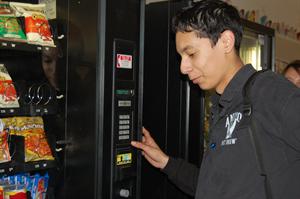 Bismark Sedano buying a snack at the vending machine during lunch