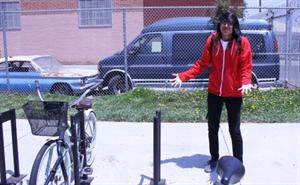 Emilio stand by the bicycle racks with no bike of his own to lock up.