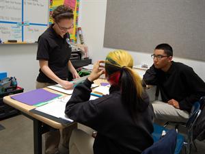 Mathematics teacher Dana Mainella assist her students in separate groups.