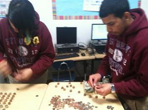 Seniors Numa Juarez and Sarah Vasquez count pennies donated by Animo Pat Brown students