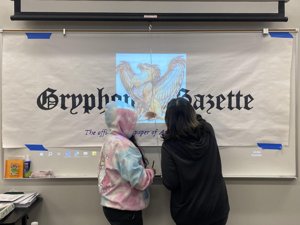 Students Samantha Castillo and Ashley Garcia working on a poster In Journalism . One of APB’s few electives . 
