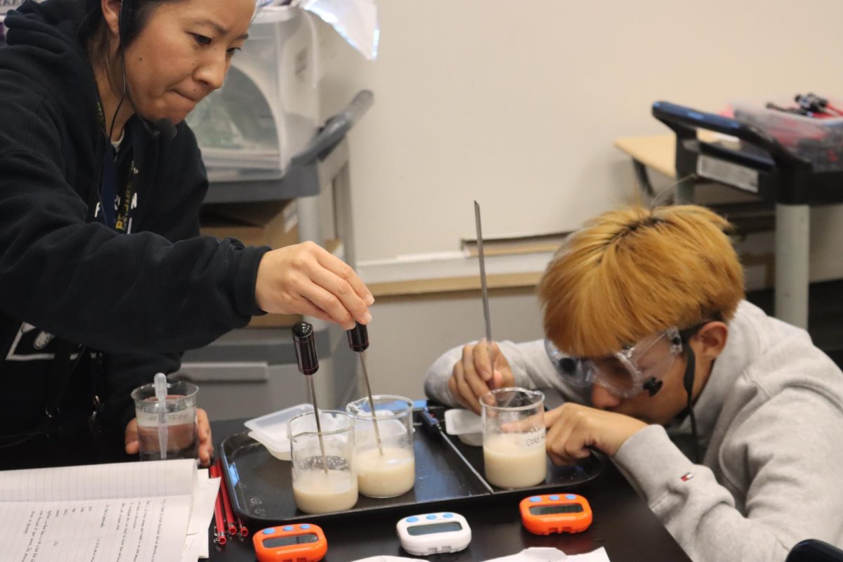 Ms. Ohara helps sophomore Oscar Coxaj during a lab in biology